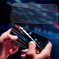 TCL 10L screen protector being applied to a phone showing a dynamic light trail wallpaper