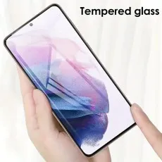 A hand holding a smartphone with a tempered glass screen protector