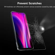 A cracked screen protector next to a phone with a vibrant display and a metallic sphere