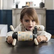 A child's wooden toy set with a cup, spoon, and a cookie on a small decorative tray.
