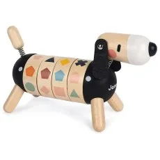 A close-up of a girl playing with a black and natural wood toy dog with a segmented body.