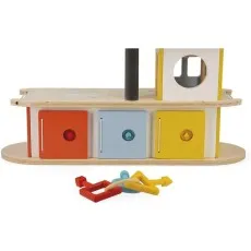 The base of a wooden toy garage, with a set of keys lying on the floor in front of it.