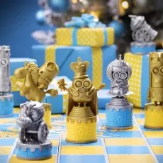 Close-up of Minions chess pieces (gold king, silver queen) on the game board with gifts