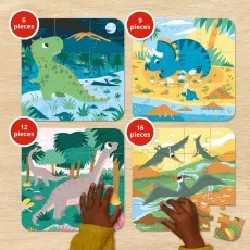 A child's hands work on a set of four dinosaur puzzles with increasing difficulty 6, 9, 12, and 16 pieces.