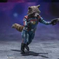Rocket Raccoon action figure in a blue suit aiming two silver pistols against a dark, cosmic background.