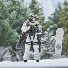 G.I. Joe Cobra Snow Serpent figure in full white gear standing by a parked, decorated snowboard.