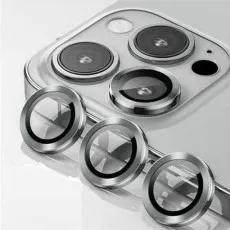 Three silver ring camera lens protectors sitting next to a triple-lens smartphone camera.